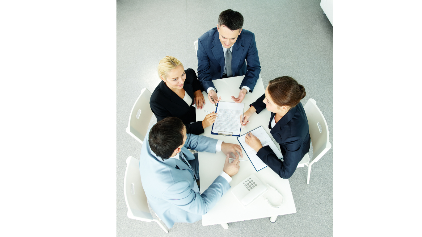 A person in a suit holds a card that says WHERE TO INVEST? with the word INVEST and a question mark in bold letters. The persons face is partially out of focus.
